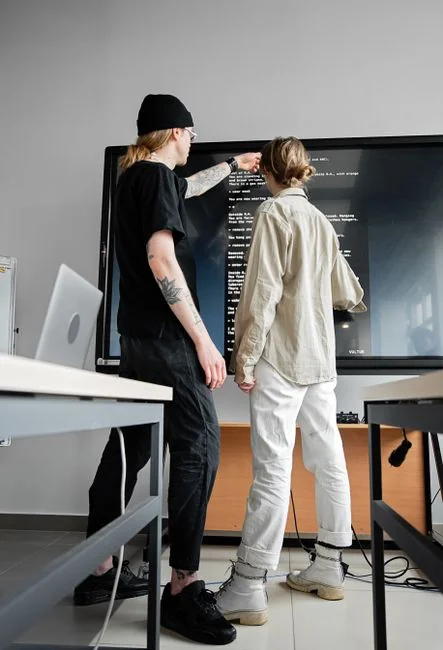 Dual monitors on a desk, showcasing web design in a modern office setting.